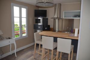 a kitchen with a counter with chairs and a kitchen island at au 10 quai violette in Saint-Valéry-sur-Somme