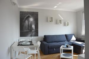 uma sala de estar com um sofá azul e uma mesa em Apartamenty Słowackiego 1 & Ogrodowa 2 em Sandomierz