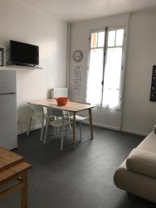 a living room with a table and chairs and a kitchen at Maison Bernadette - Rez-de-chaussée in Vitry-sur-Seine