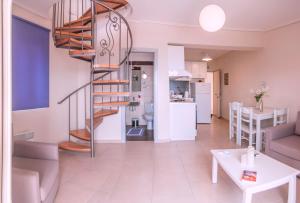 a living room with a spiral staircase and a kitchen at Thea Hotel in Marmari