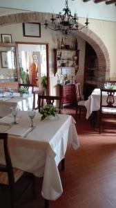 uma sala de jantar com duas mesas com toalha de mesa branca em La Romita Ospitalità Rurale Familiare em Montisi