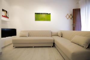 a living room with a couch and a flat screen tv at ArtHouse in San Vito lo Capo