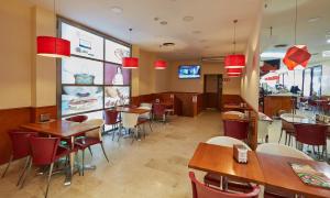a restaurant with tables and chairs and a tv at Aparthotel Milord's Suites in Benidorm