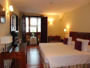 a hotel room with two beds and a television at Quinta de Villanueva in Colombres