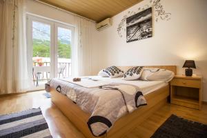 a bedroom with a bed and a large window at Apartment & Rooms Marigold in Baška Voda