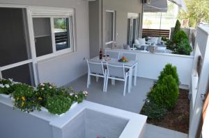 patio ze stołem i krzesłami w domu w obiekcie Aqua Luxury Villas w mieście Nea Potidaea