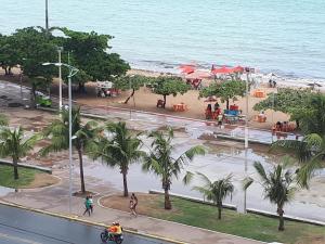 a view of a beach with palm trees and people riding bikes at Maceió Pajuçara Ed. Neo 1 in Maceió