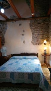 a bedroom with a bed and a stone wall at Il Borgo dei Laghi in Revine Lago