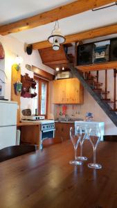 2 copas de vino sentadas en una mesa de madera en una cocina en Il Borgo dei Laghi en Revine Lago