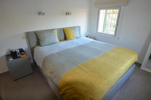 - une chambre avec un grand lit et une couverture jaune et bleue dans l'établissement Domaine de Claude, à La Cadière-dʼAzur
