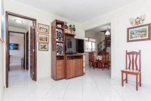 a living room with a television and a dining room at apartamento de cobertura praia do forte cabo frio in Škorak