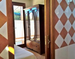 a bedroom with a wooden cabinet and a mirror at Arcamyrtus in Alghero