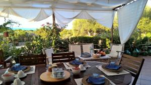 a table with plates of food on a patio at Arcamyrtus in Alghero