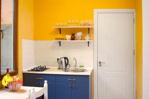 a kitchen with a sink and a yellow wall at Sunburst Apartment in Tbilisi City