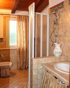 a bathroom with a sink and a toilet and a vase at Villa Plaia in Castellammare del Golfo