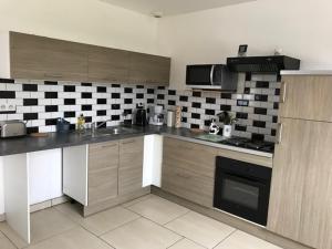 a kitchen with a black and white checkered wall at le clos du caribou in Beaumont-Hamel