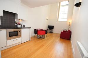 ノリッジにあるNorwich Central Modern Apartmentのキッチン(テーブル、赤い椅子付)