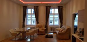 - un salon avec des chaises, une table et des fenêtres dans l'établissement Prague Centre Apartments, à Prague