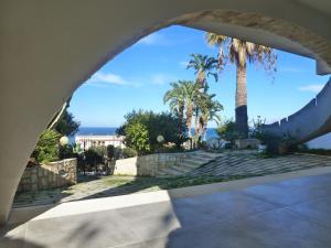 uma vista para o oceano a partir de um edifício com palmeiras em Casa Calendule em Alcamo Marina