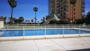 a fence around a swimming pool in a city at Benalmadena ,apartamento-Estudio primera Línea de Playa in Benalmádena