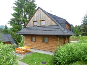 uma cabina de madeira com uma mesa e um banco à sua frente em Drevenica u Maťa, Terchová em Terchová