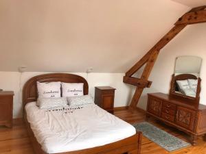 1 dormitorio con 1 cama con sábanas blancas y espejo en le clos du caribou, en Beaumont-Hamel
