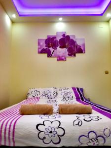 a bedroom with a bed with flowers on it at Maslina Rooms in Smederevo