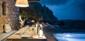a long table in a restaurant with a painting on the wall at Tainaron Blue Retreat in Vathia
