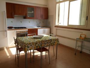 a kitchen with a table with chairs and a refrigerator at Akron B&B in SantʼAlessio Siculo