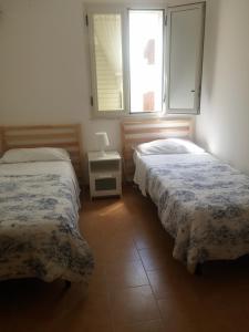 a bedroom with two beds and a window at Akron B&B in SantʼAlessio Siculo