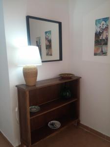 a lamp on a wooden shelf in a room at Akron B&B in SantʼAlessio Siculo