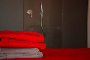 a pile of red towels sitting on top of a bed at Ingrappa Sporthouse in Borso del Grappa