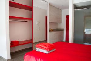 a bedroom with a red bed and a mirror at Ingrappa Sporthouse in Borso del Grappa