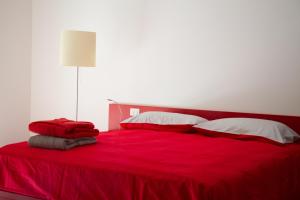 a red bed with white pillows and a red blanket at Ingrappa Sporthouse in Borso del Grappa