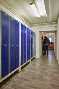 a row of lockers in a hallway with people walking at Pauli Hostel in Hamburg