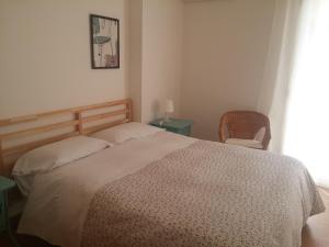 a bedroom with a bed and a chair and a window at Akron B&B in SantʼAlessio Siculo