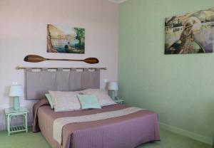レ・ザンドリにあるLa Chaîne D'orのベッドルーム1室(ベッド1台付)が備わります。壁には絵画が飾られています。
