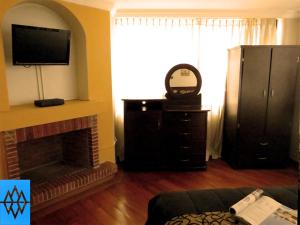 キトにあるAltura Rooms & Suitesのリビングルーム(暖炉、テレビ付)