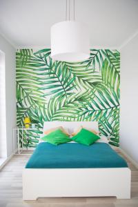 a bedroom with a bed with a green leafy wall at A.S HOME Kościuszki II in Wrocław