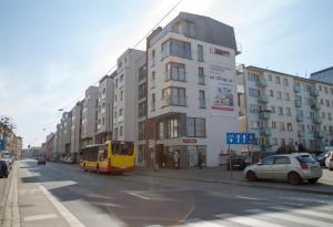 ヴロツワフにあるA.S. HOME Kościuszki Apartament dwupoziomowyの黄色いバスが建物の横を走行