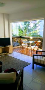 a living room with a table and chairs on a balcony at Ap Riviera uma quadra da praia in Bertioga