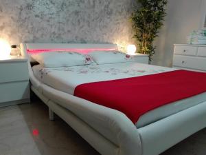 1 dormitorio con cama blanca y manta roja en Mecenate Cozy Flat, en Milán