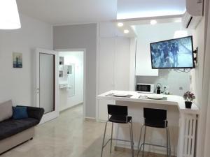 una cucina bianca con bar con due sgabelli di Mecenate Cozy Flat a Milano