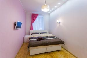 - une chambre avec un lit et un mur rose dans l'établissement Апартаменты Дворец Спорта, à Kiev