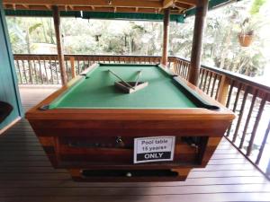 a pool table on a deck with a sign on it at Rainforest Eco Lodge in Suva