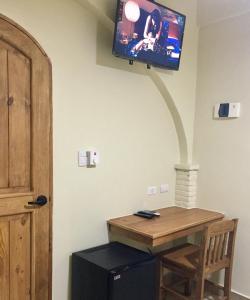 um quarto com uma mesa e uma televisão na parede em Hotel Yamilí em Punta Cana