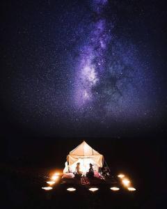 a group of people sitting in a tent under the stars at Camp Desert Stars in Mhamid