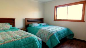 - une chambre avec 2 lits et une fenêtre dans l'établissement Hospedaje Las Animas Valdivia, à Valdivia