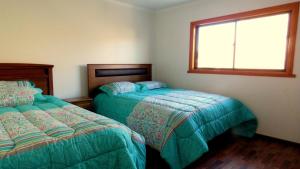 a bedroom with two beds and a window at Hospedaje Las Animas Valdivia in Valdivia