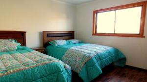 1 dormitorio con 2 camas y ventana en Hospedaje Las Animas Valdivia, en Valdivia